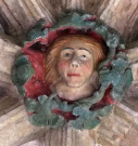 8  woman's head with large garland - cloister south walk - early 15th century