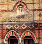 coloured brick patterns and niche with figure, in Norman Road