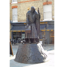 2.  Chaucer, dressed as a pilgrim, faces Eastbridge Hospital